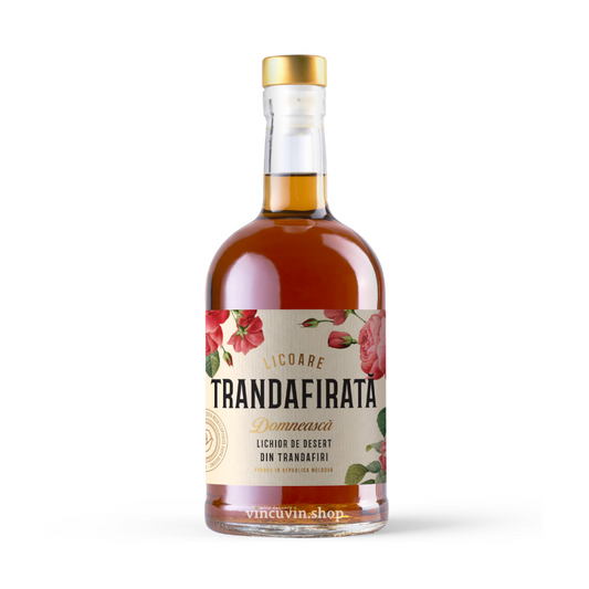 A bottle of Trandafirata Domnească liqueur de desert, featuring an amber-brown liquid inside a clear glass bottle with a gold cap and a cream-colored label decorated with red roses, set against a plain white background.