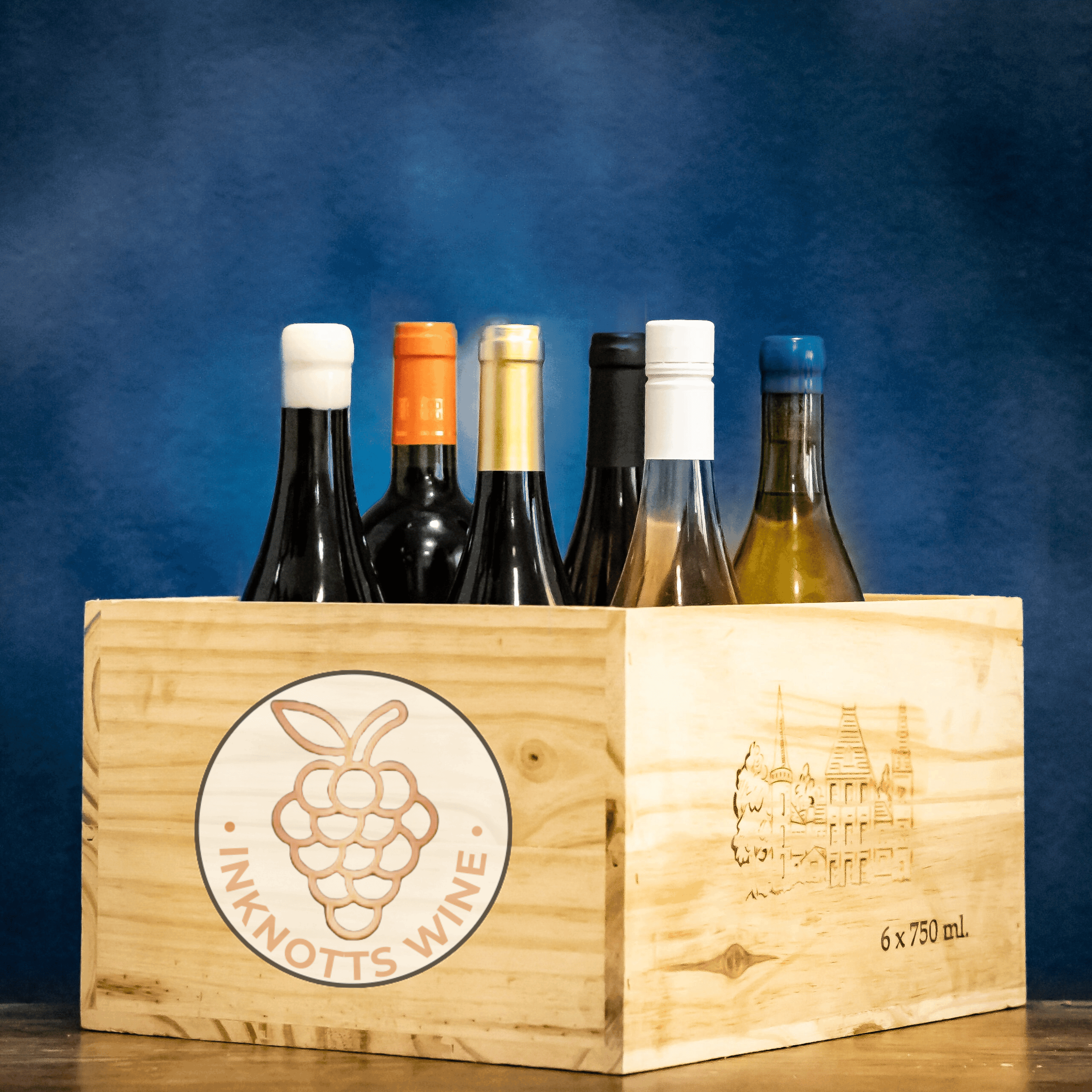 6 bottles of red, white, rose, orange, sparkling wine in a wooden crate